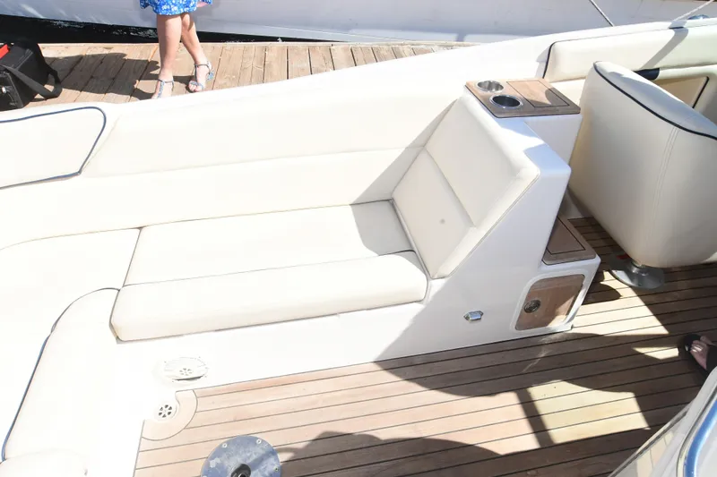 Slide: The Image of 2005 Chris-Craft Corsair 28 boat interior with white seating and wooden deck. - 12