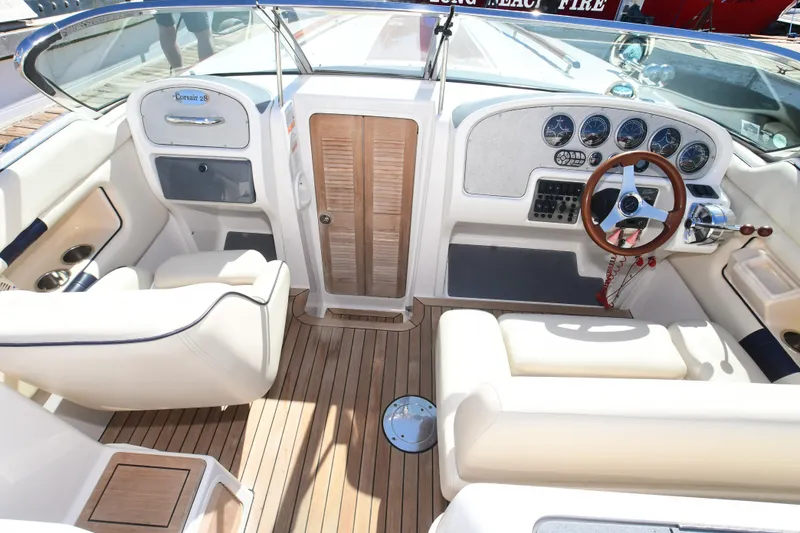 Slide: The Image of 2005 Chris-Craft Corsair 28 boat interior with wooden dashboard and leather seating. - 3