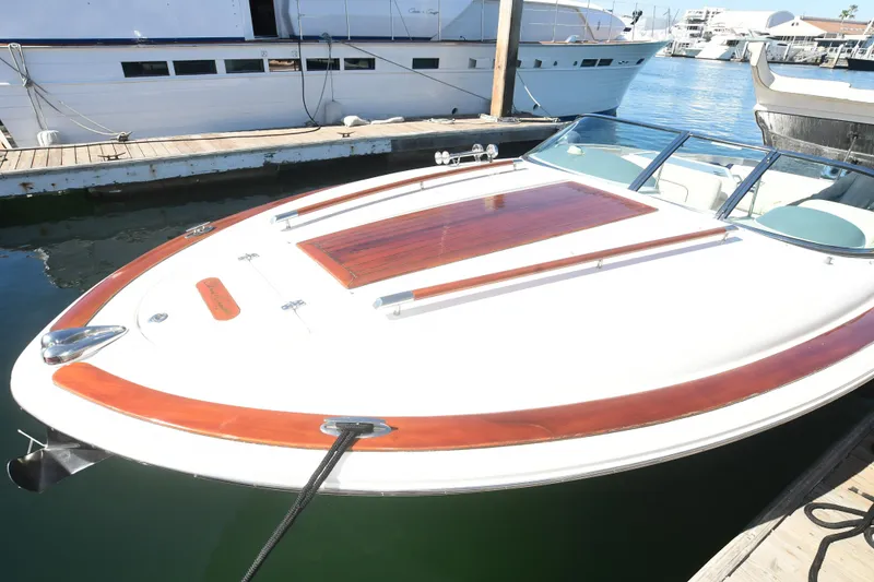 Slide: The Image of 2005 Chris-Craft Corsair 28 boat docked, featuring sleek design and wooden accents. - 5