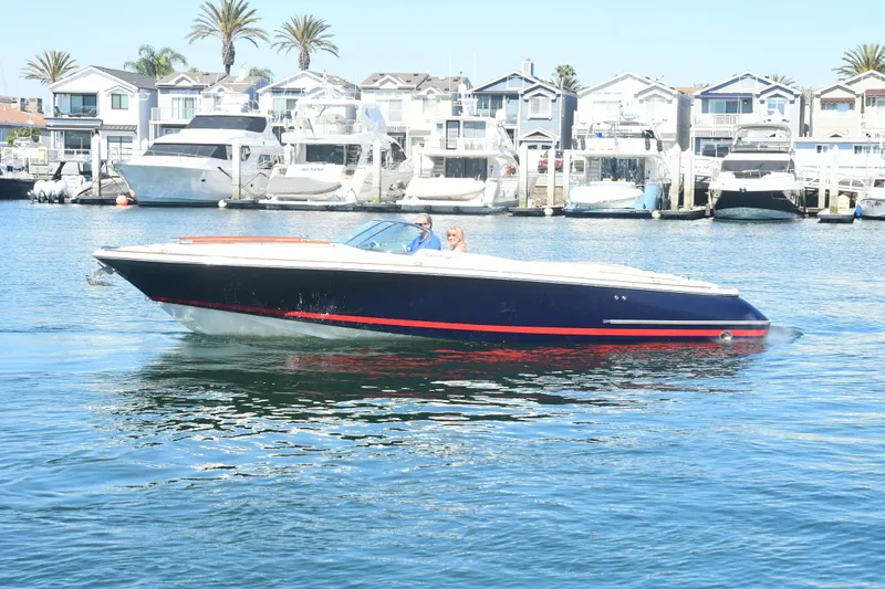 Slide: The Image of 2005 Chris-Craft Corsair 28 boat cruising in a marina with waterfront homes. - 7