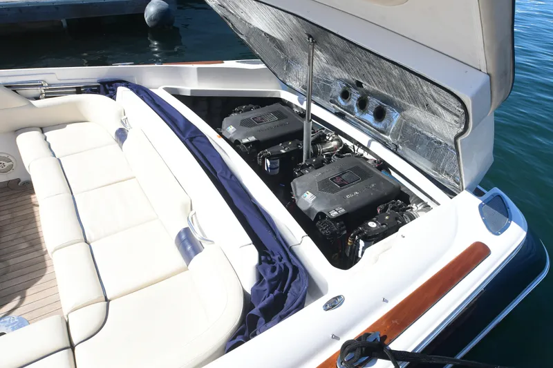 Slide: The Image of 2005 Chris-Craft Corsair 28 boat engine compartment with twin engines and seating area. - 9