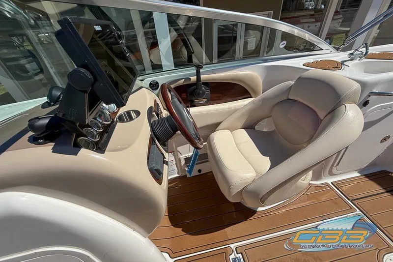 Slide: The Image of 2006 Chaparral Sunesta 274 boat cockpit with steering wheel and beige seating. - 12