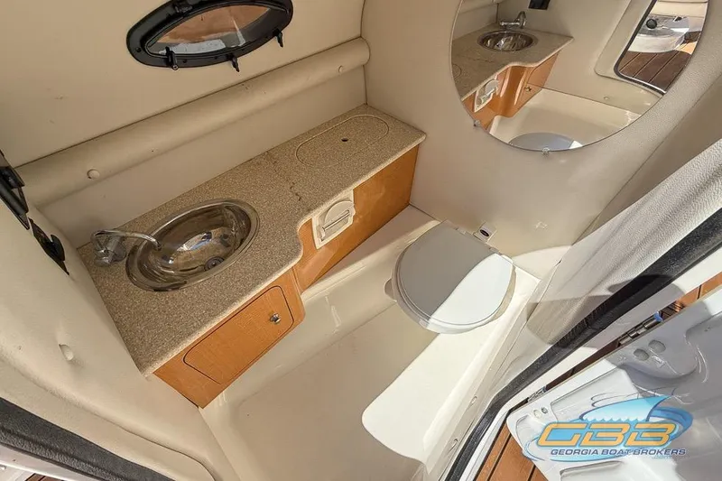 Slide: The Image of 2006 Chaparral Sunesta 274 boat bathroom with sink, toilet, and mirror. - 14