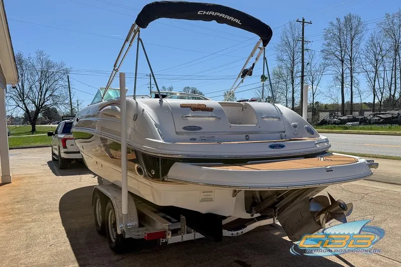 Slide: The Image of 2006 Chaparral Sunesta 274 boat on trailer, parked outdoors under clear blue sky. - 23