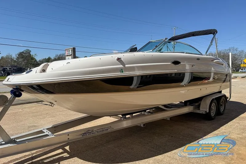 Slide: The Image of 2006 Chaparral Sunesta 274 boat on trailer, displayed outdoors under clear blue sky. - 24