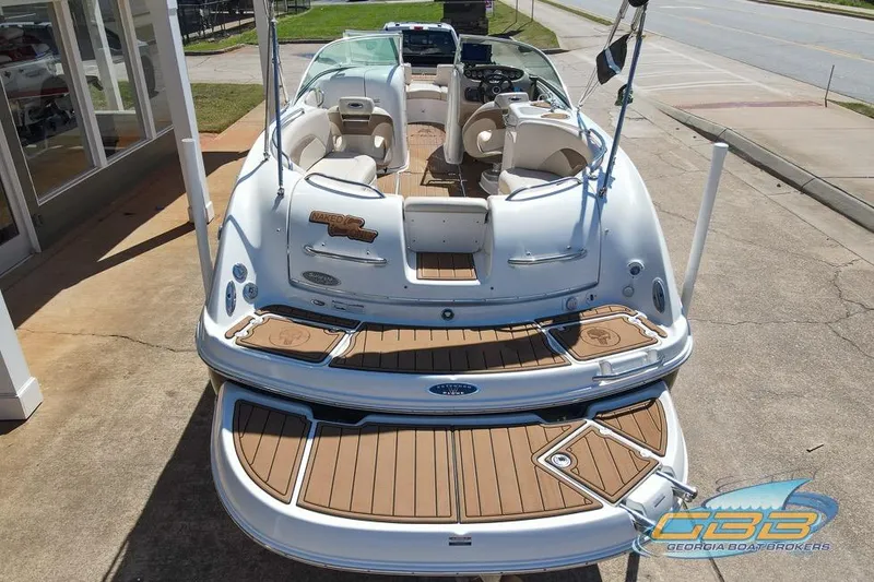 Slide: The Image of 2006 Chaparral Sunesta 274 boat with spacious deck and seating, displayed outdoors. - 9
