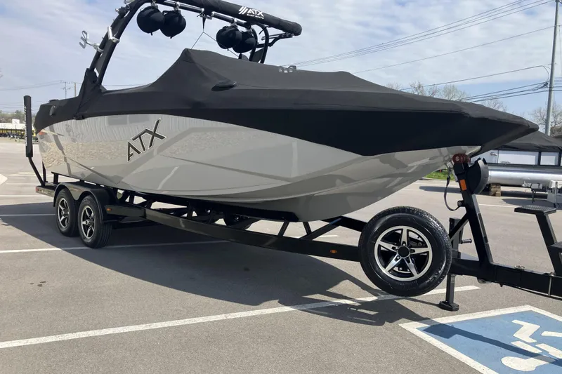 Slide: The Image of 2020 ATX Surf Boats 24 Type-S on trailer, covered and parked in lot. - 2