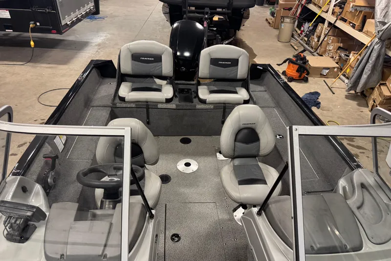 Slide: The Image of 2019 Tracker Pro Guide V-175 Combo boat interior with seating and steering wheel in a garage. - 15