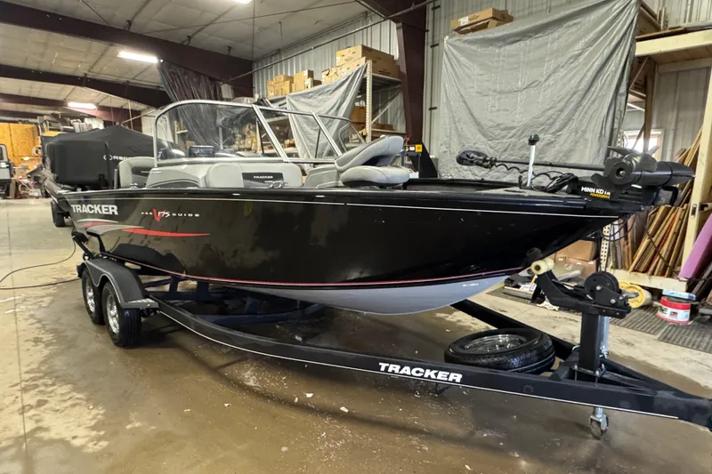 Slide: The Image of 2019 Tracker Pro Guide V-175 Combo boat in a warehouse setting. - 2