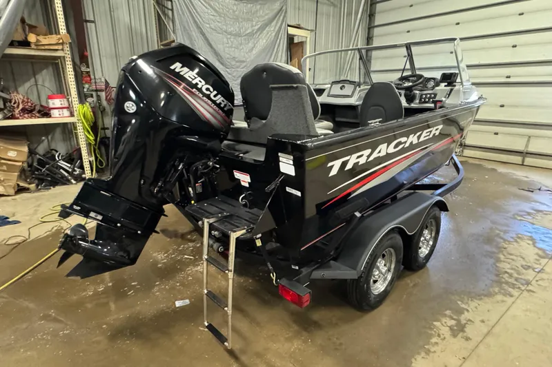 Slide: The Image of 2019 Tracker Pro Guide V-175 Combo boat with Mercury engine in a garage. - 3