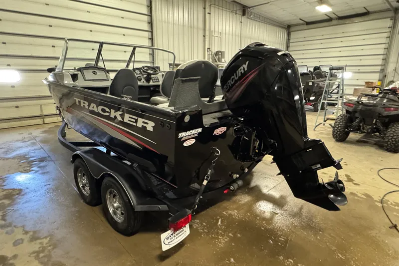 Slide: The Image of 2019 Tracker Pro Guide V-175 Combo boat with Mercury engine in a garage setting. - 4