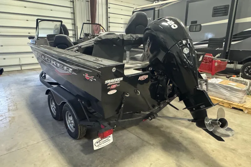 Slide: The Image of 2023 Tracker Targa V-19 WT boat in garage, featuring powerful outboard motor. - 4