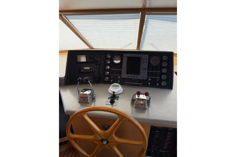 Slide: The Image of Pilothouse of 1991 Ocean Alexander 520, featuring navigation controls and steering wheel. - 12
