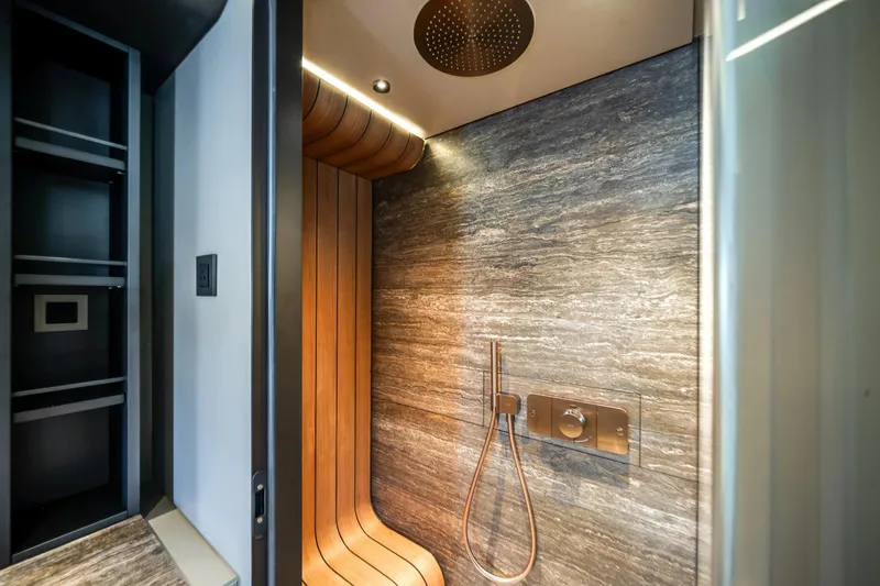 Slide: The Image of Luxurious shower area on the 2026 Azimut Magellano 30M yacht, featuring elegant wood and stone finishes. - 49