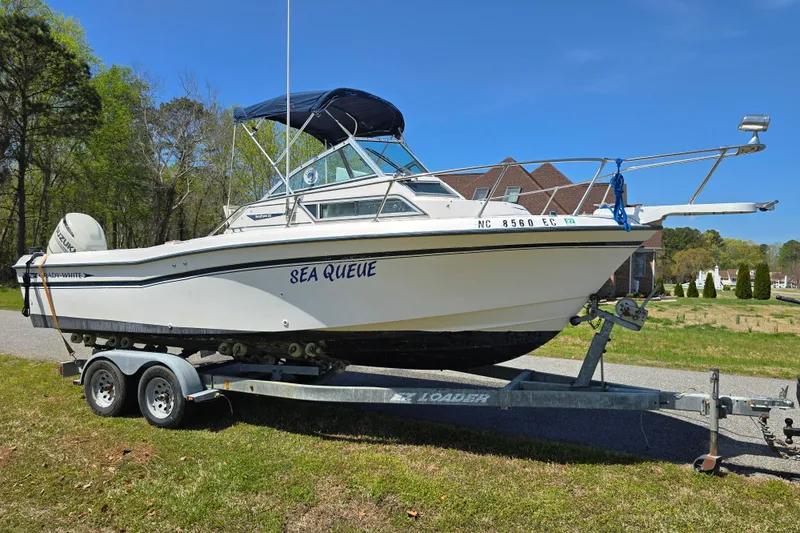 The Image of 1992 Grady White 226 boat on trailer, named "Sea Queue," parked outdoors. - 1
