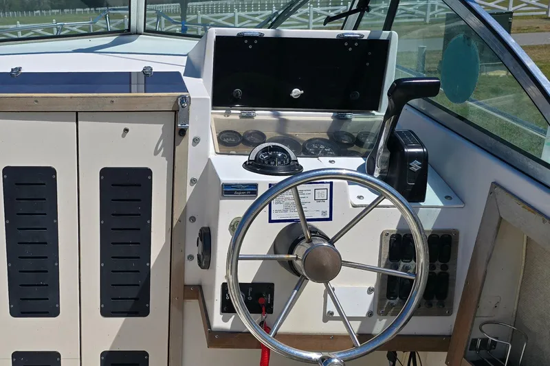 Slide: The Image of 1992 Grady White 226 boat helm with steering wheel and control panel. - 19