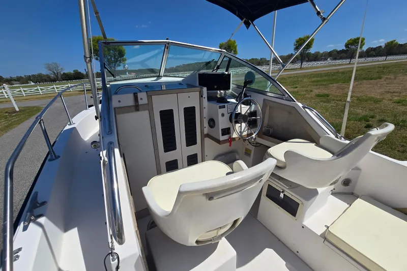 Slide: The Image of 1992 Grady White 226 boat interior with steering wheel and seating under blue sky. - 22