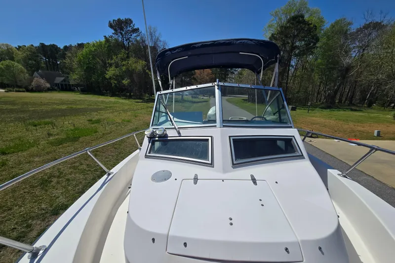 Slide: The Image of 1992 Grady White 226 boat with canopy, parked on a grassy area under clear blue sky. - 24