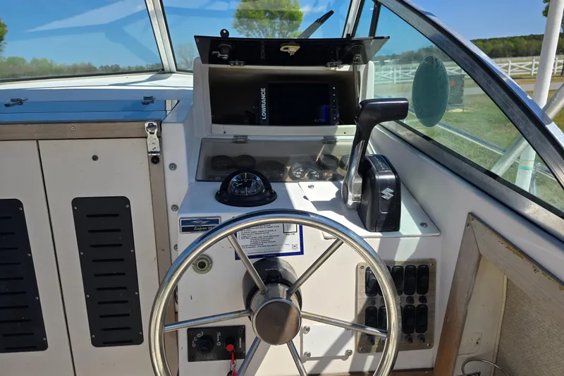 Slide: The Image of 1992 Grady White 226 boat dashboard with steering wheel and controls. - 29