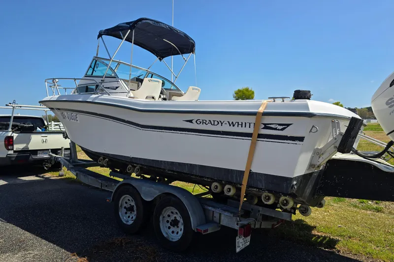 Slide: The Image of 1992 Grady White 226 boat on trailer, parked outdoors under clear blue sky. - 30