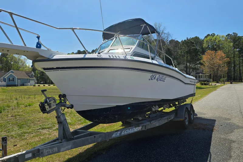 Slide: The Image of 1992 Grady White 226 boat on trailer, parked on a suburban street. - 31