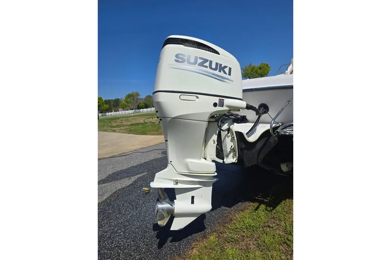 Slide: The Image of Suzuki outboard motor on a 1992 Grady White 226 boat, parked on pavement. - 4