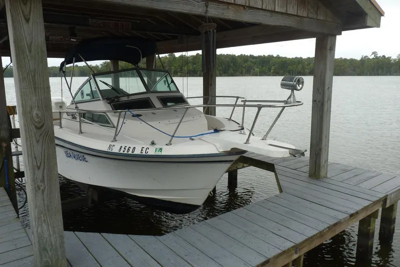 Slide: The Image of 1992 Grady White 226 boat docked under a wooden shelter on a lake. - 5