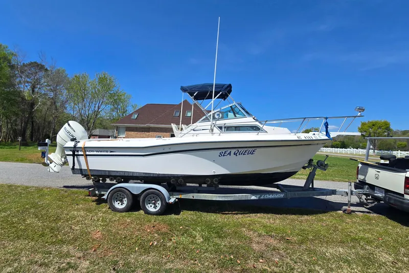 Slide: The Image of 1992 Grady White 226 boat on trailer, parked outdoors under clear blue sky. - 6