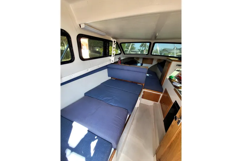 Slide: The Image of Interior of 2001 Skipjack 262 Flybridge boat with blue seating and wooden cabinetry. - 15