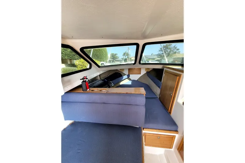 Slide: The Image of Interior of 2001 Skipjack 262 Flybridge boat with blue seating and wooden storage. - 16