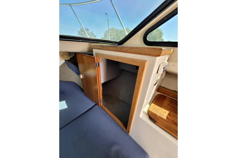 Slide: The Image of Interior view of 2001 Skipjack 262 Flybridge boat with open wooden cabinet. - 17