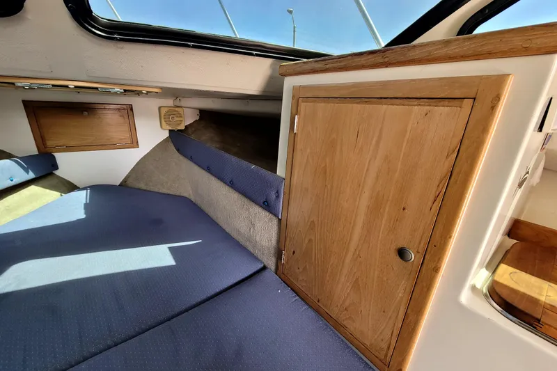 Slide: The Image of Interior cabin of 2001 Skipjack 262 Flybridge with blue cushions and wooden cabinetry. - 22