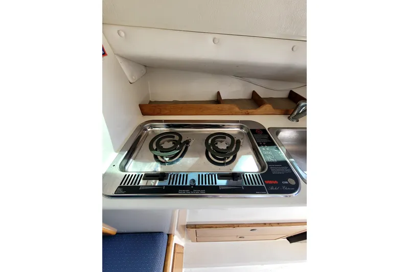 Slide: The Image of Compact kitchen area in a 2001 Skipjack 262 Flybridge boat with stove and sink. - 25