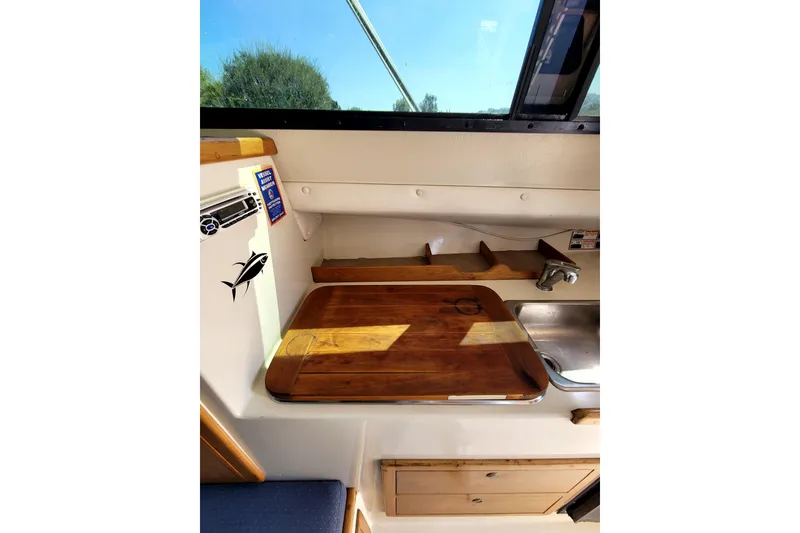 Slide: The Image of Interior of 2001 Skipjack 262 Flybridge boat with wooden countertop and sink. - 26