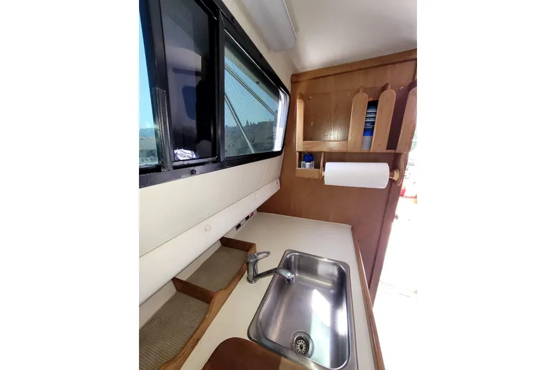 Slide: The Image of Interior of 2001 Skipjack 262 Flybridge boat featuring a compact kitchen sink area. - 27