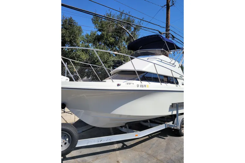 Slide: The Image of 2001 Skipjack 262 Flybridge boat on trailer, parked outdoors. - 6