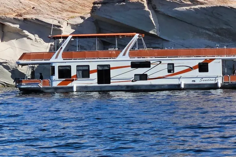 The Image of Houseboat "Sundancer" by American Waterways, 2007, cruising near rocky shoreline. - 0