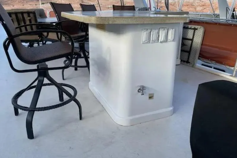 Slide: The Image of Outdoor bar area on a 2007 American Waterways Sundancer boat, featuring swivel chairs and a countertop. - 18