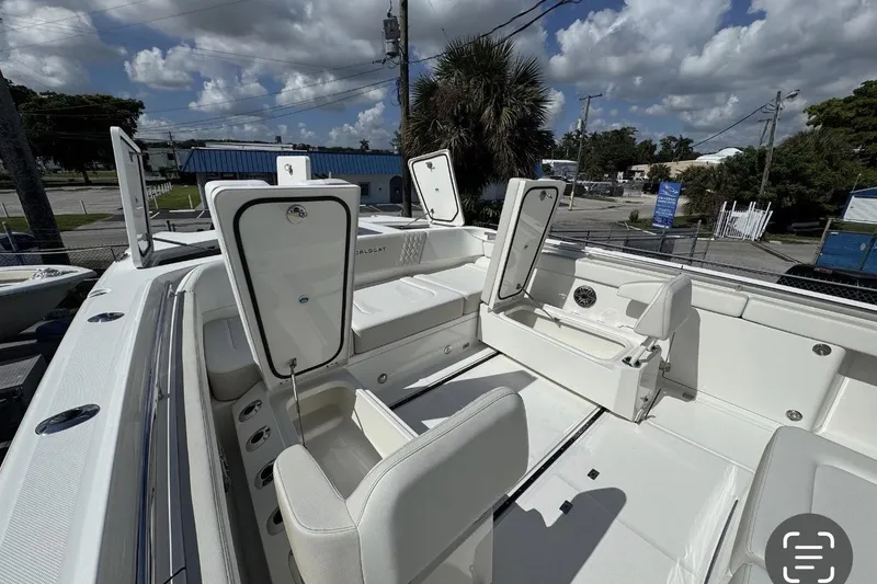 Slide: The Image of 2026 World Cat 400 CC-X boat interior with open storage compartments under a cloudy sky. - 7