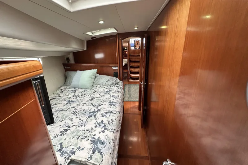 Slide: The Image of Luxurious cabin interior of a 2003 Beneteau 57 yacht with wooden finishes and cozy bedding. - 10