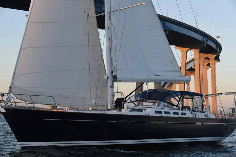 Slide: The Image of Sailing yacht Beneteau 57, 2003 model, cruising under a bridge at sunset. - 105