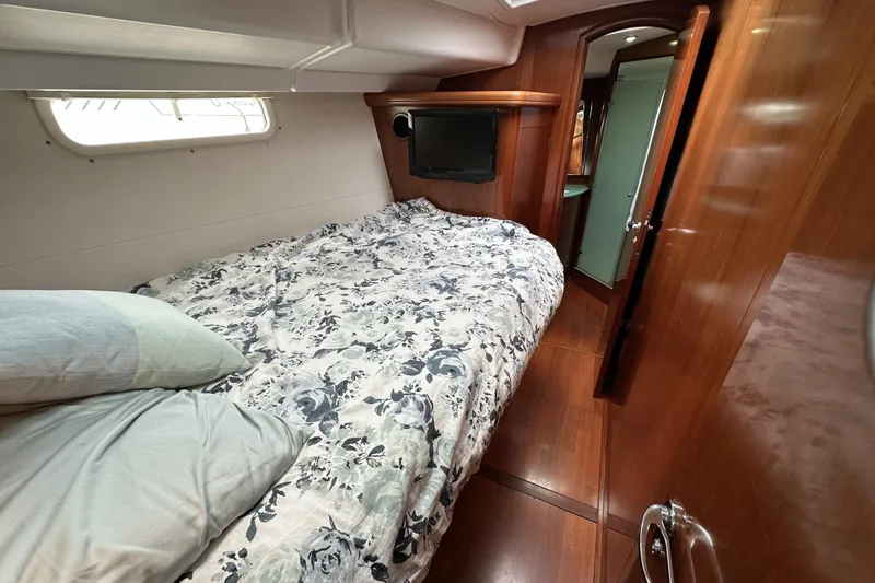 Slide: The Image of Luxurious cabin interior of a 2003 Beneteau 57 yacht with cozy bedding and wood finish. - 11