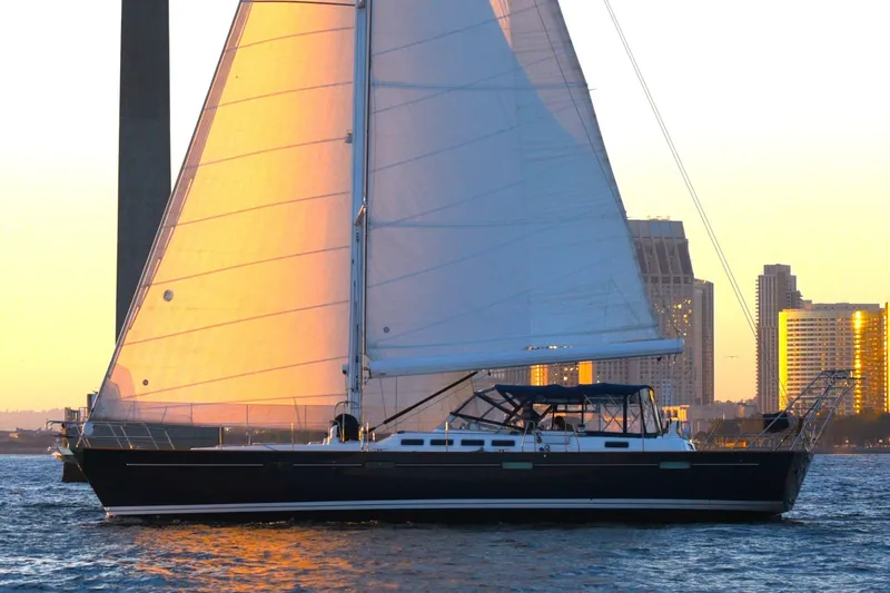 Slide: The Image of Sailing yacht Beneteau 57, 2003 model, at sunset near city skyline. - 110
