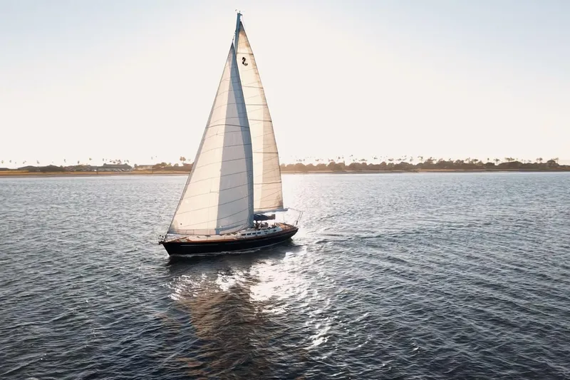 Slide: The Image of Sailing yacht Beneteau 57 from 2003 gliding on open water at sunset. - 114