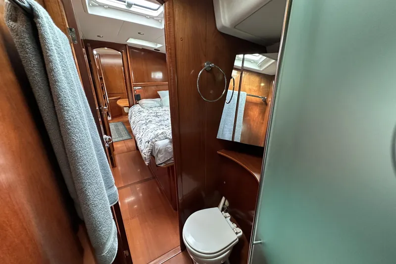 Slide: The Image of Luxurious interior of 2003 Beneteau 57 yacht, featuring a cozy bedroom and bathroom. - 14