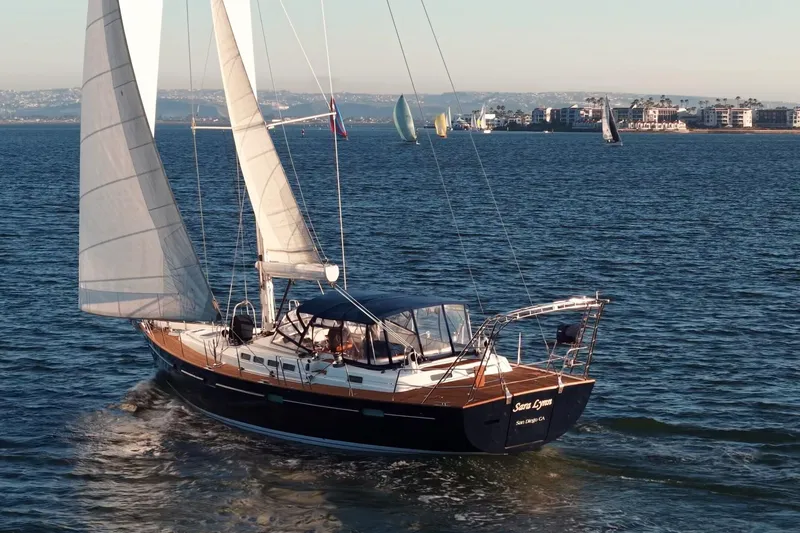 Slide: The Image of Sailing yacht Beneteau 57, 2003 model, cruising on open water near coastal buildings. - 2