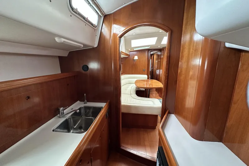 Slide: The Image of Luxurious interior of a 2003 Beneteau 57 yacht featuring a cozy dining area and sleek kitchen. - 27