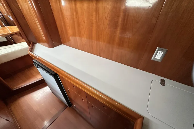 Slide: The Image of Interior of 2003 Beneteau 57 yacht with wood paneling and compact fridge. - 28