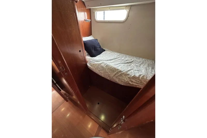 Slide: The Image of Cozy cabin interior of 2003 Beneteau 57 yacht with wooden finish and bedding. - 36