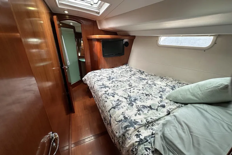 Slide: The Image of Luxurious cabin interior of a 2003 Beneteau 57 yacht with cozy bedding and wooden finishes. - 4